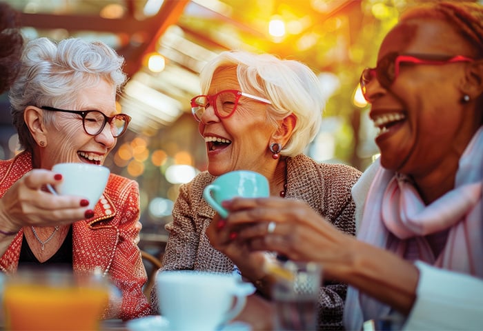 Smiling senior living residents drinking coffee together