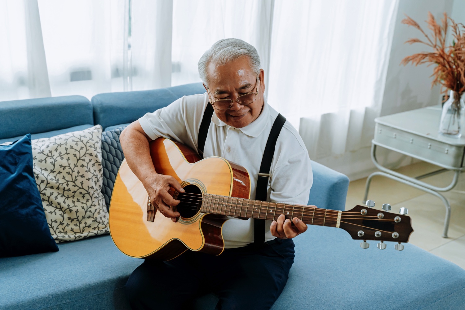 Asian senior man playing acoustic guitar