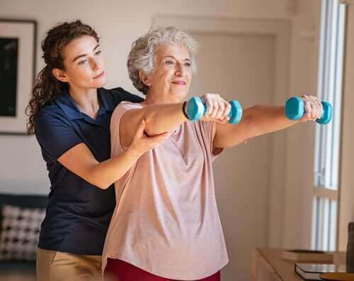 senior woman and caregiver exercising