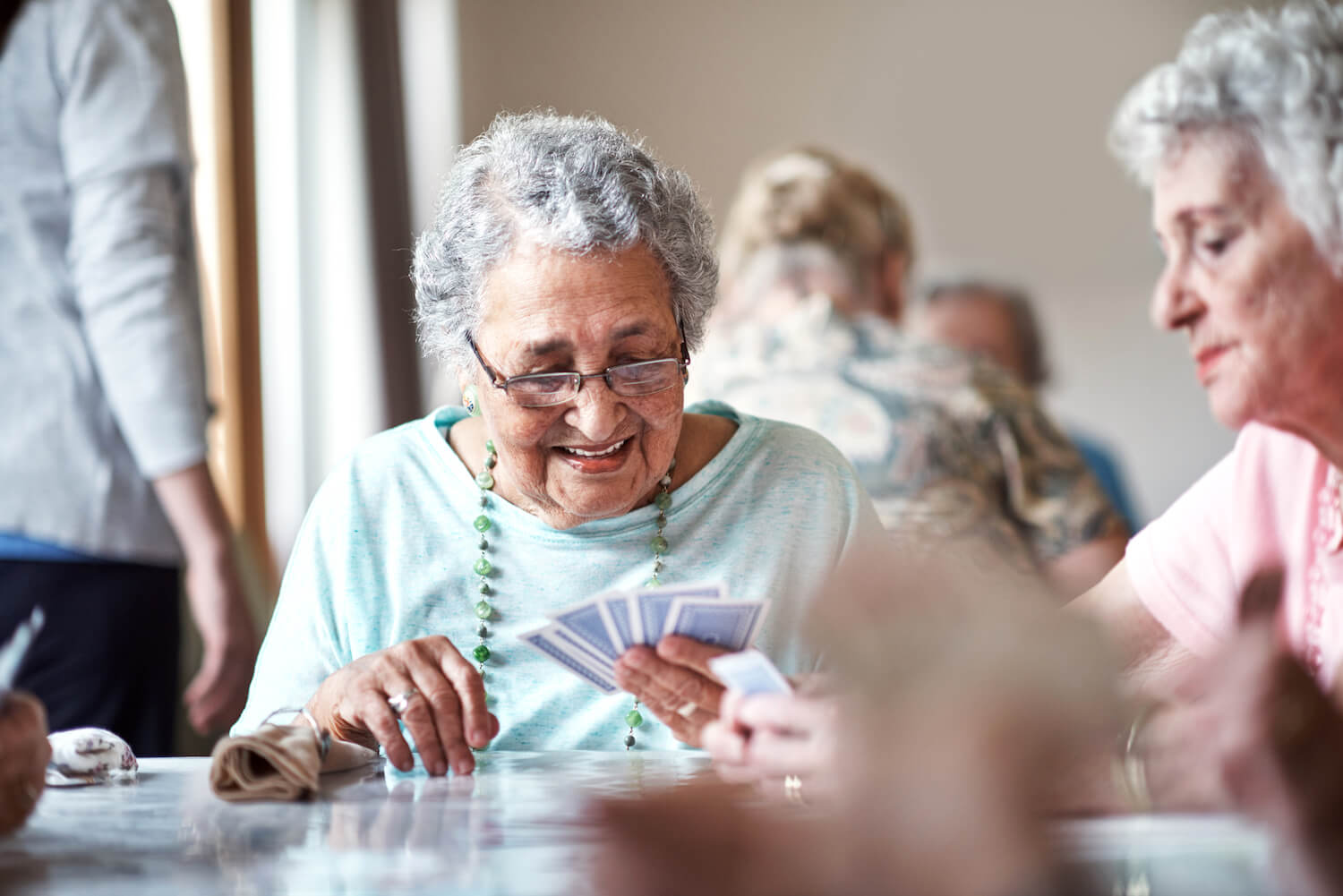 Senior women playing cards at Cedarhurst Senior Living community