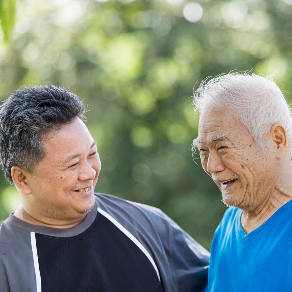 Younger man smiling with senior outdoors-1