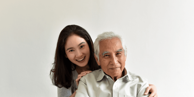 Adult child embracing parent while talking about senior living options