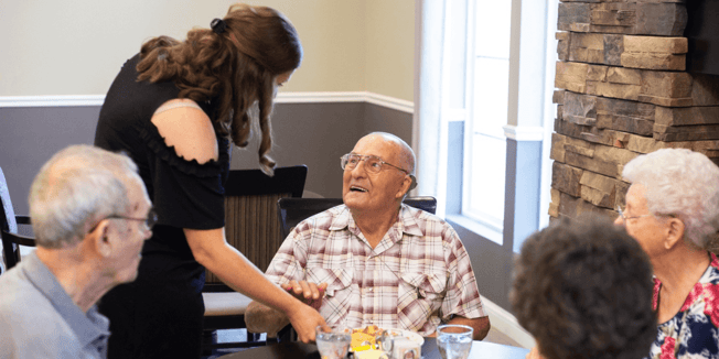 Senior living caretaker interacting with a resident of Cedarhurst Senior Living. 