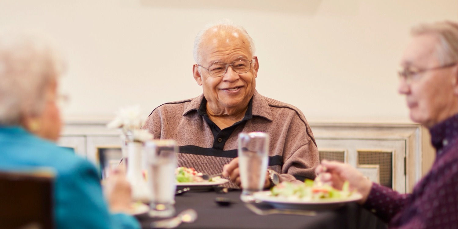 Senior friends eating a meal together. 