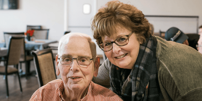 A Cedarhurst team member and senior resident in the community dining room, talking about senior living