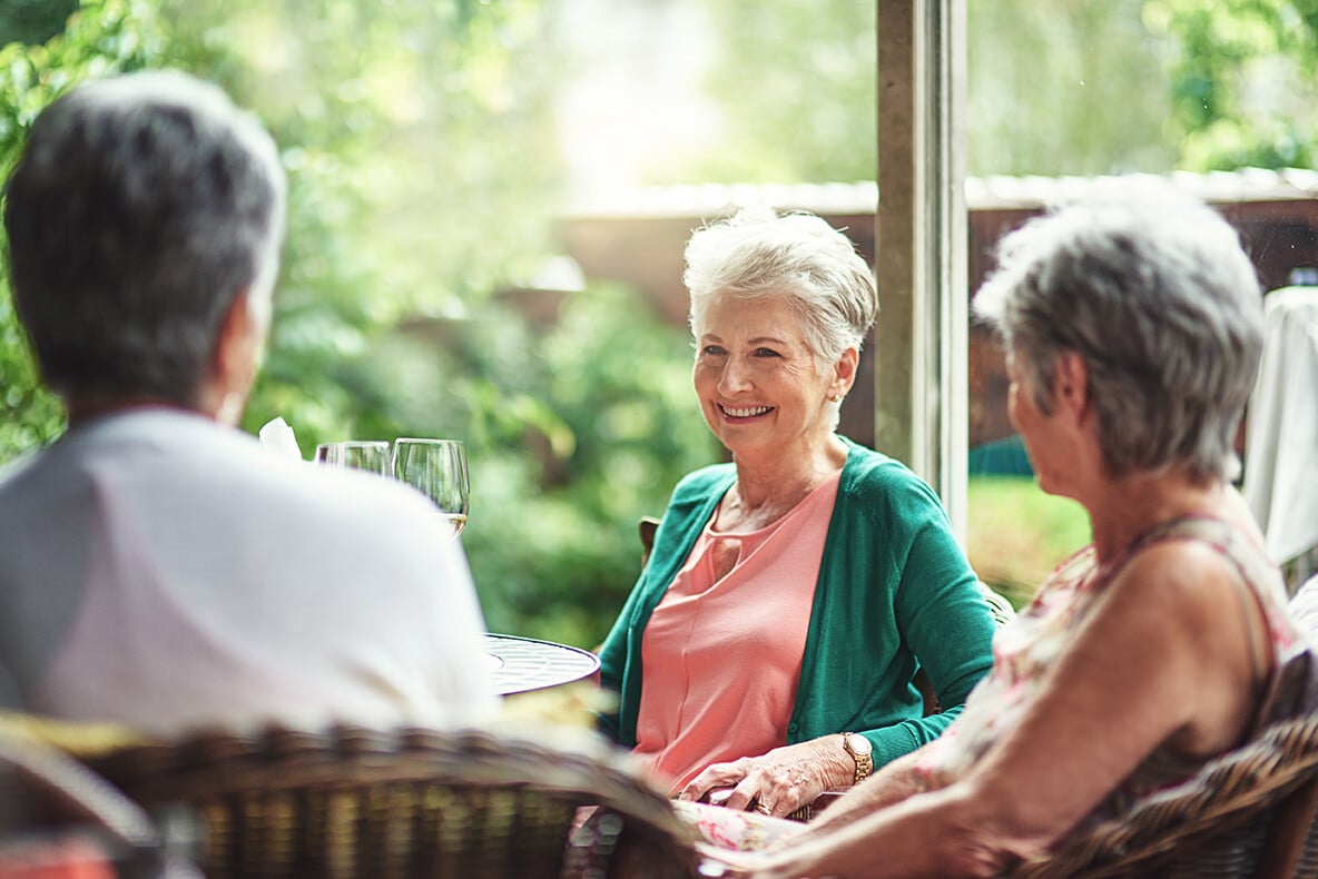 senior women smiling and having a conversation at senior living community