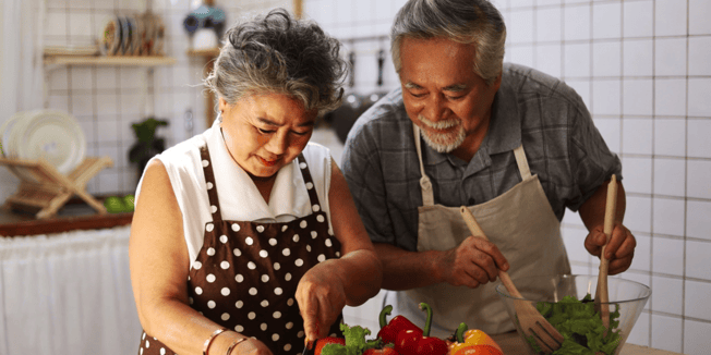 A senior couple cooking together in a kitchen