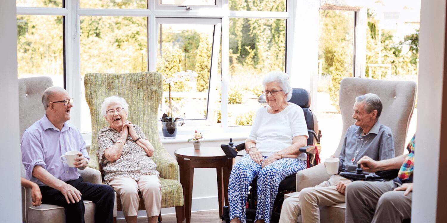 Cedarhurst residents laughing and smiling together in a living room